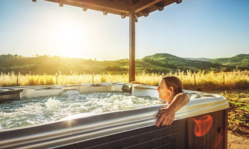 Woman in whirlpool hot tub at sunset